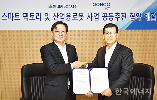 서유성 현대로보틱스 사업대표(오른쪽)와 손건재 포스코ICT 사장(왼쪽)이 스마트팩토리 사업 진출에 대한 업무협약을 맺은 뒤 함께 포즈를 취하고 있다.