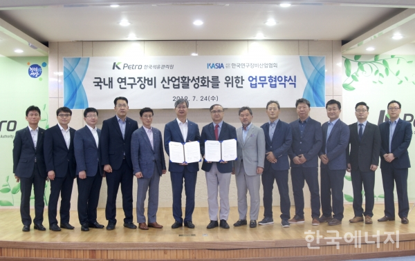 한국석유관리원 손주석 이사장(왼쪽에서 여섯 번째)과 한국연구장비산업협회 이덕희 회장이 업무협약을 체결하고, 참석자들이 기념촬영을 하고 있다.